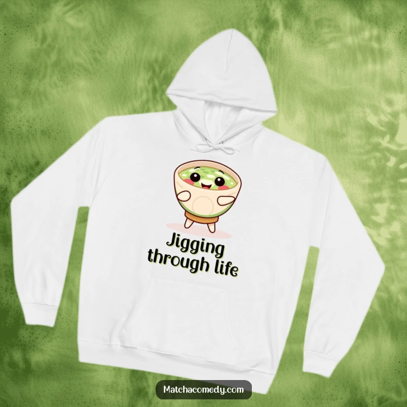 Funny smiling matcha bowl captured mid-jig, printed on a soft hoodie for maximum comfort and cheer.