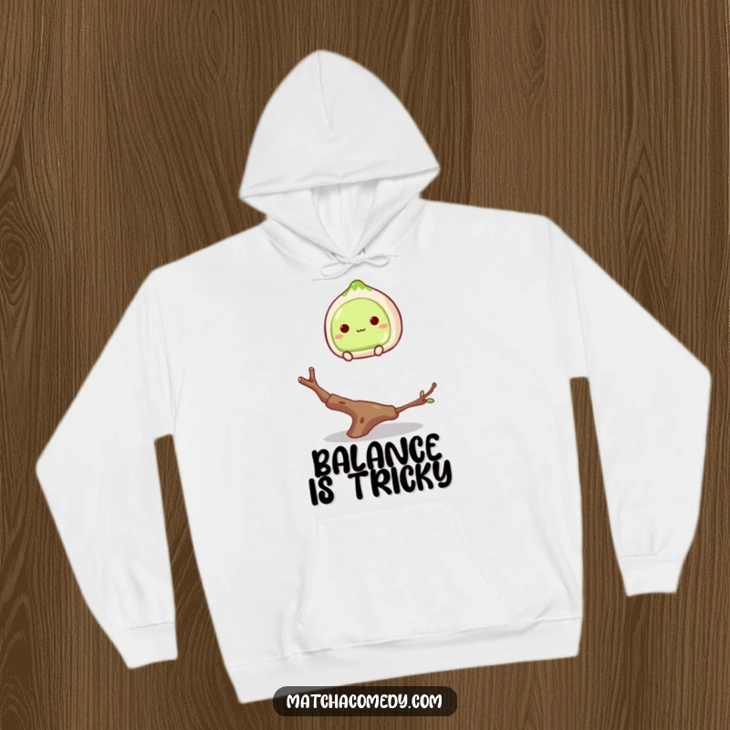 Funny matcha mochi balancing on a twig design on a cozy hoodie, capturing a sweet and humorous moment.