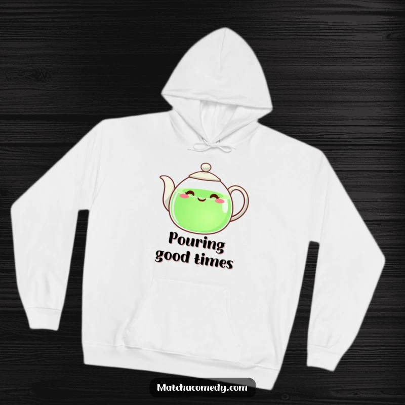 Funny teapot with a happy countenance, pouring green liquid, printed on a soft hoodie.