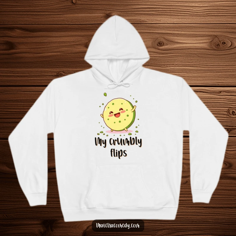 Funny, smiling matcha cookie doing a cartwheel and scattering green crumbs, featured on this warm and humorous hoodie.